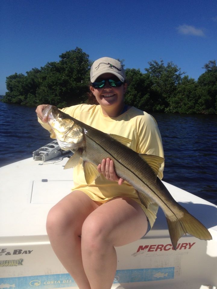 Captain Morgan's daughter holding a fish on the boat in Boca Grande.
