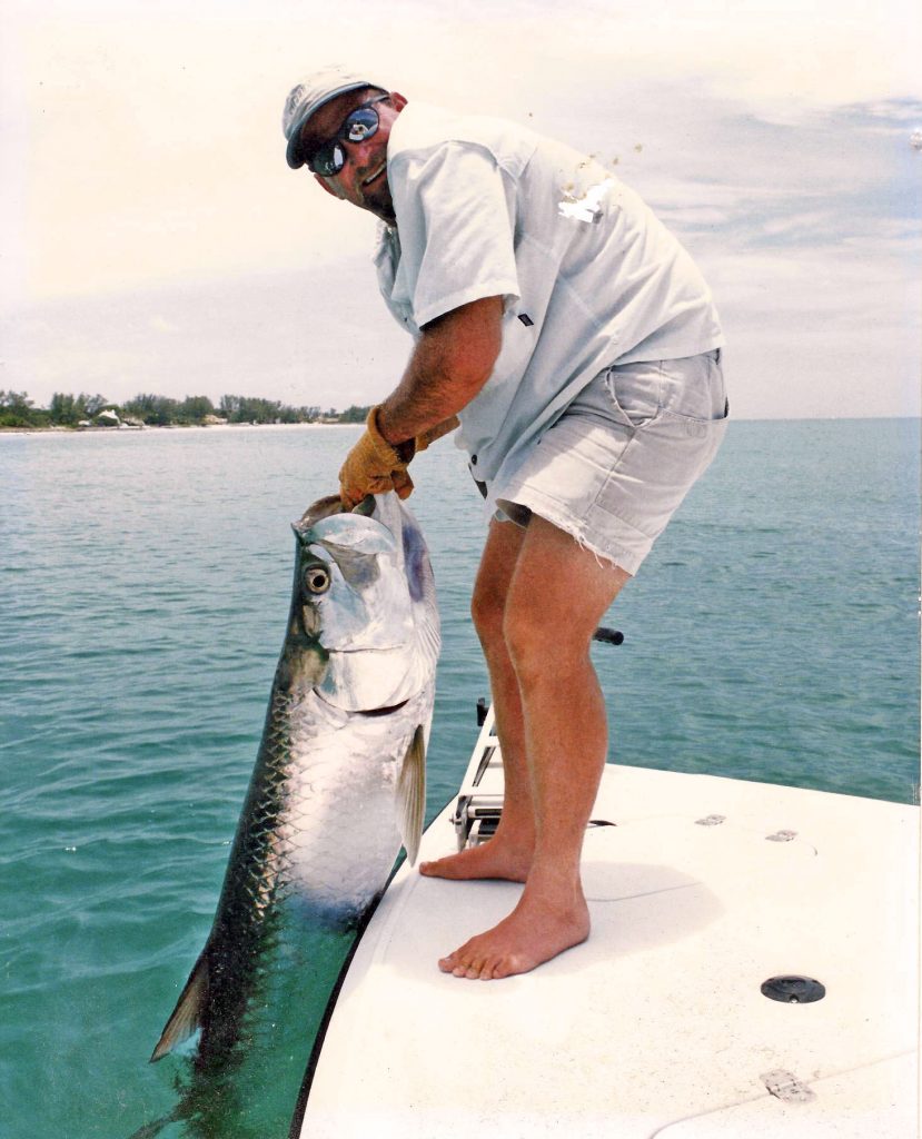Captain Morgan holds a large tarpon by its mouth during a fishing trip in Boca Grande.